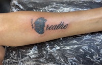 a tattoo with the word breathe on it